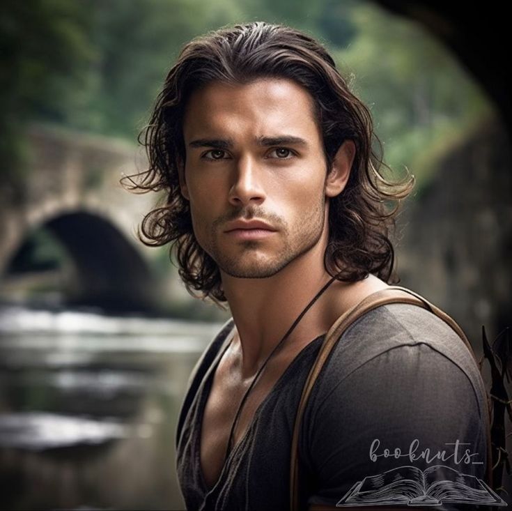 a man with long hair standing in front of a stone bridge and looking at the camera