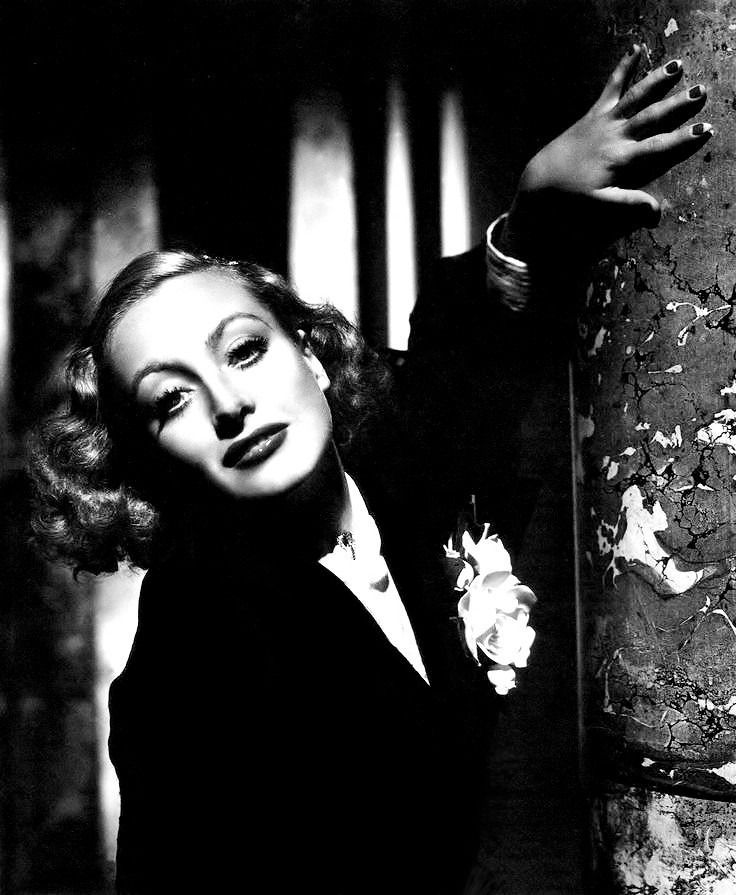 black and white photograph of a woman leaning against a wall with her hand on the wall