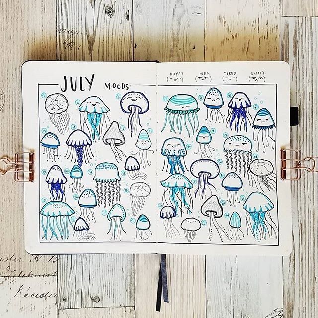 a notebook with jellyfish drawn on it and the words july written in black ink