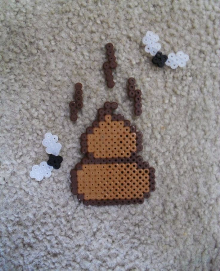 a piece of art made out of perler beads on the floor next to some sheep