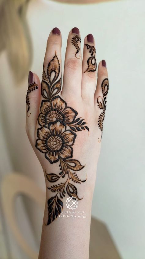 a woman's hand with hennap on it and flowers painted on the palm