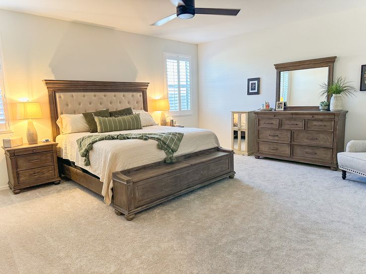 a bedroom with a bed, dressers and chair in it's center area