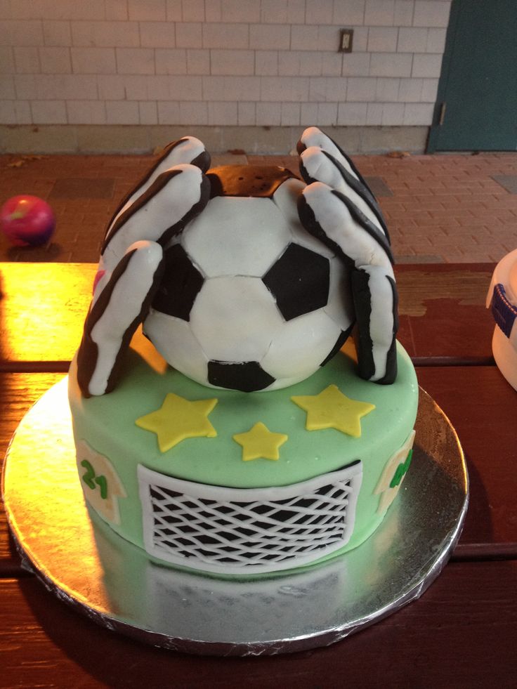 a cake with a soccer ball on top and stars around the bottom, sitting on a table