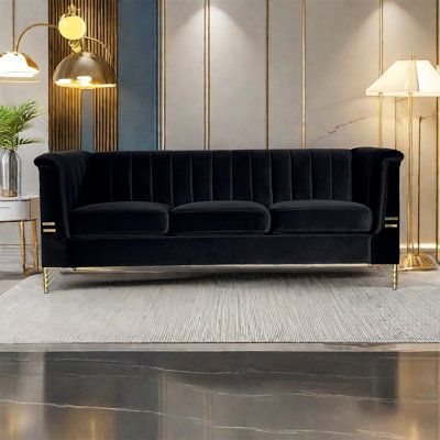 a black velvet couch sitting on top of a white rug