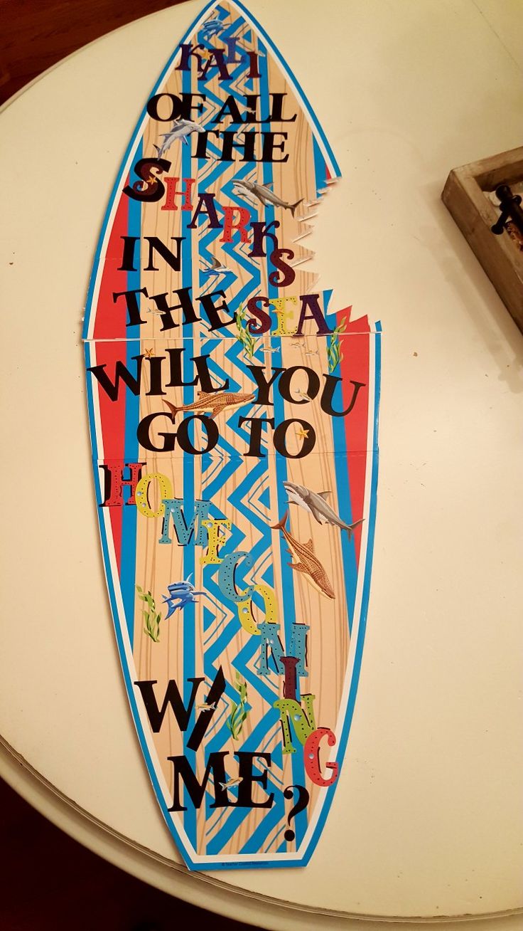 a surfboard with words on it sitting on top of a table