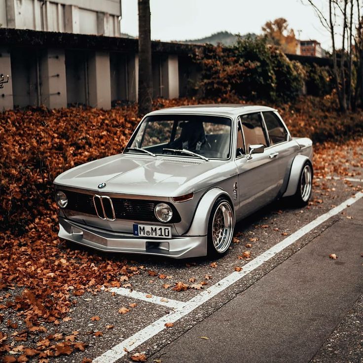 an old bmw is parked on the side of the road