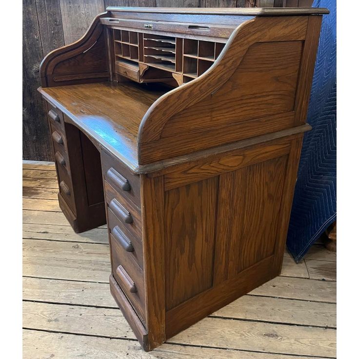 an old wooden desk with drawers on the bottom and one drawer open to reveal a file cabinet