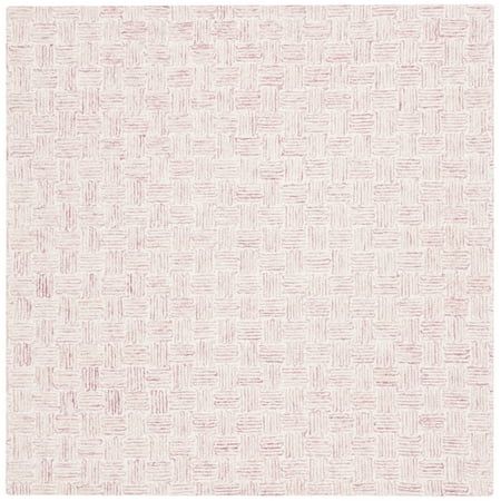 a white and pink rug with small squares on the bottom, in an irregular pattern