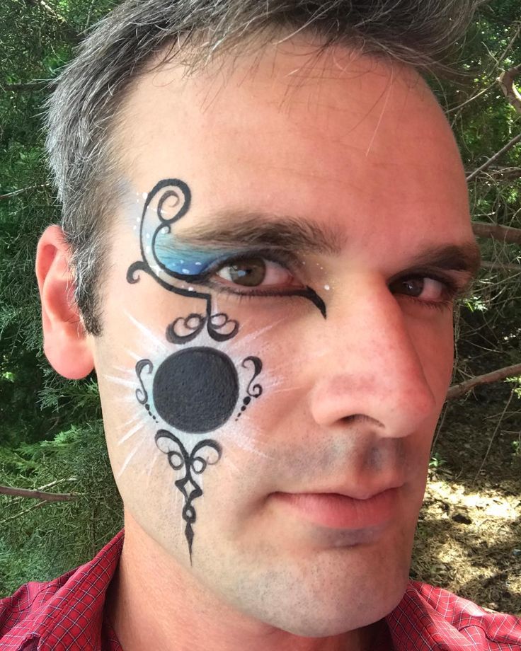 a man has his face painted with black and white designs