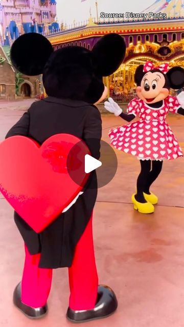 mickey and minnie mouse dancing in front of the amusement park