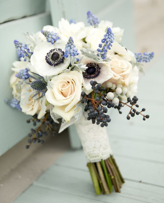 a bridal bouquet sitting on the ground next to a blue bench with white flowers