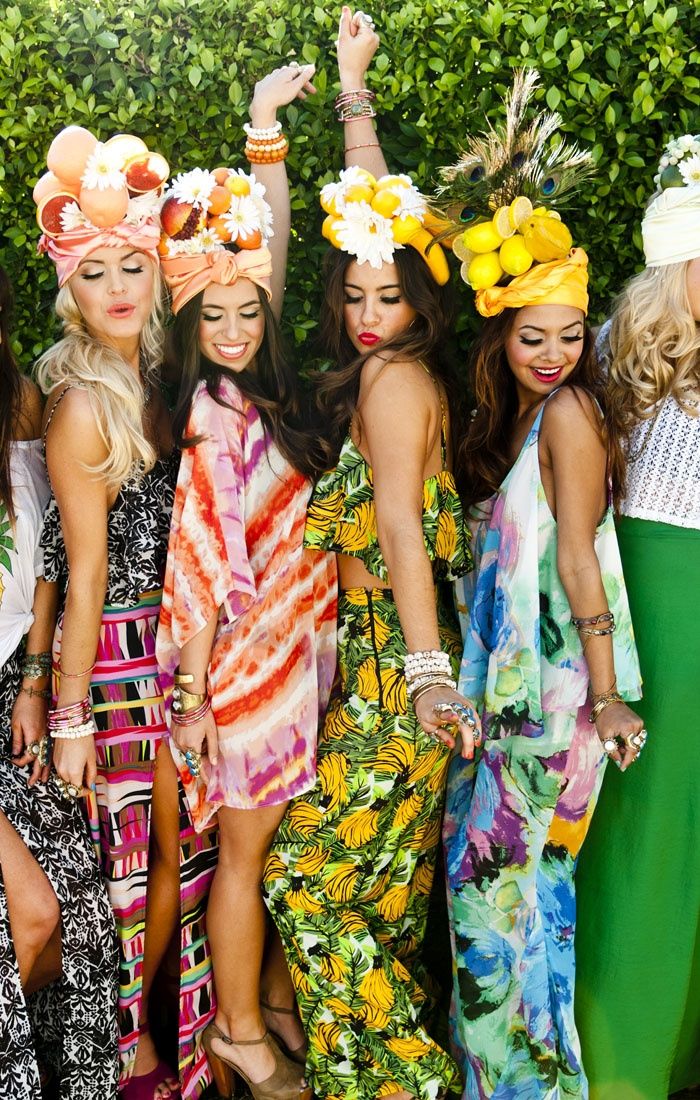 a group of women standing next to each other in front of a pool and trees