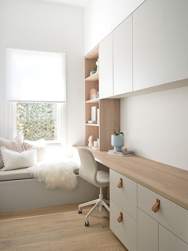 a white room with a window, desk and chair next to the window sill