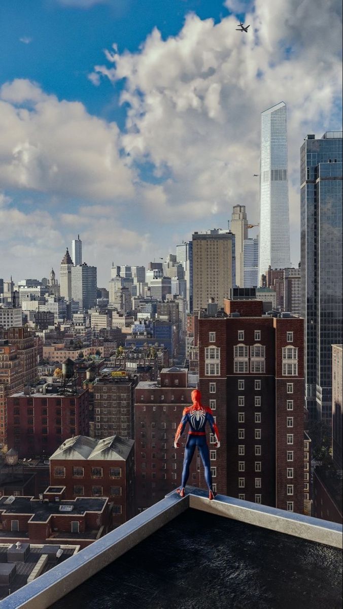 a man standing on top of a roof next to tall buildings