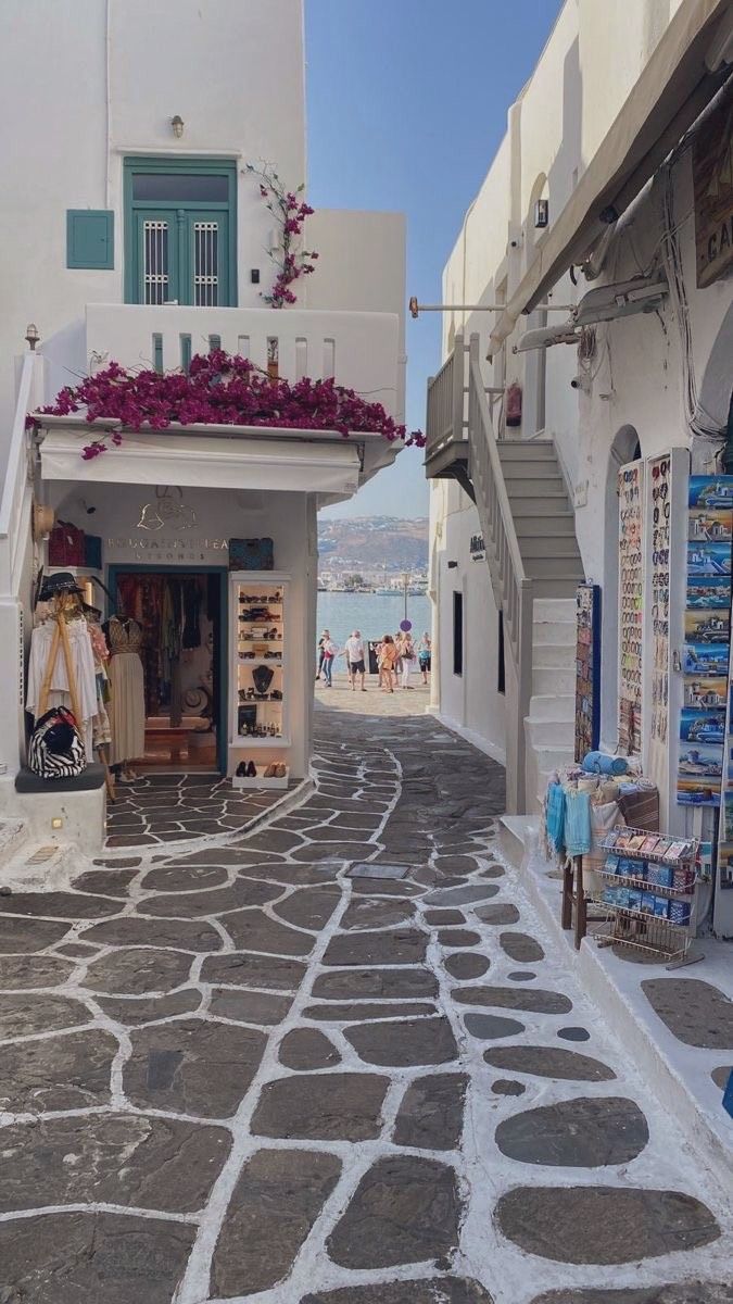 an alley way with shops and people walking down it