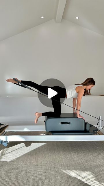 a woman is doing an exercise on a rowing machine in a room with white walls