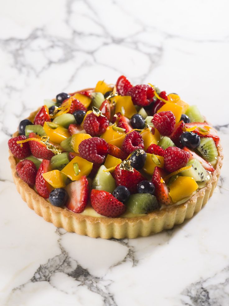 a fruit tart on a marble counter top