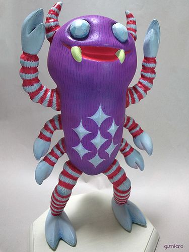 a purple toy with red and white stripes on it's legs, arms and feet