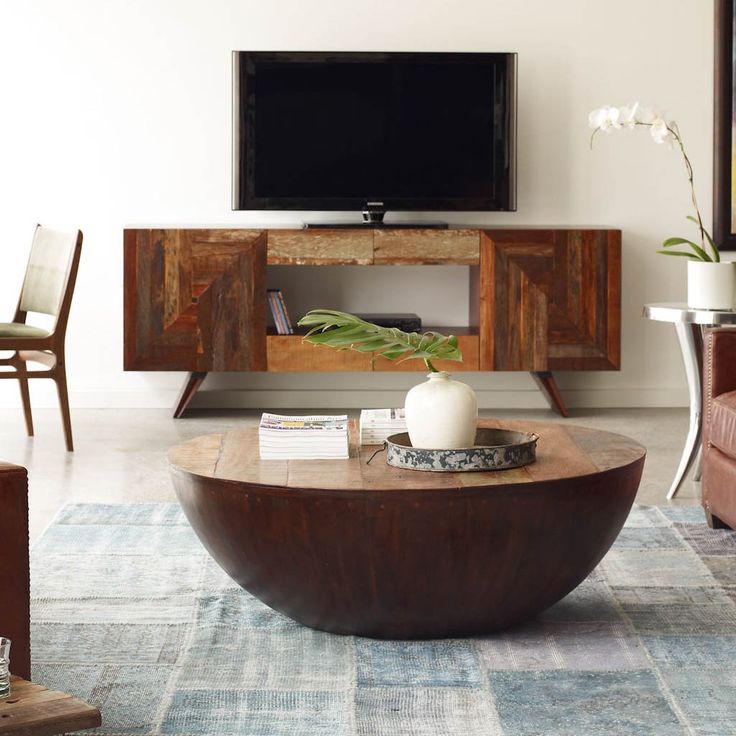 a living room with a couch, coffee table and television on top of the entertainment center