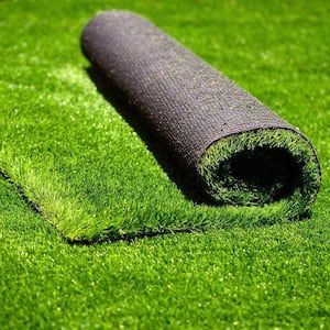 a roll of turf laying on top of a green field next to a black mat