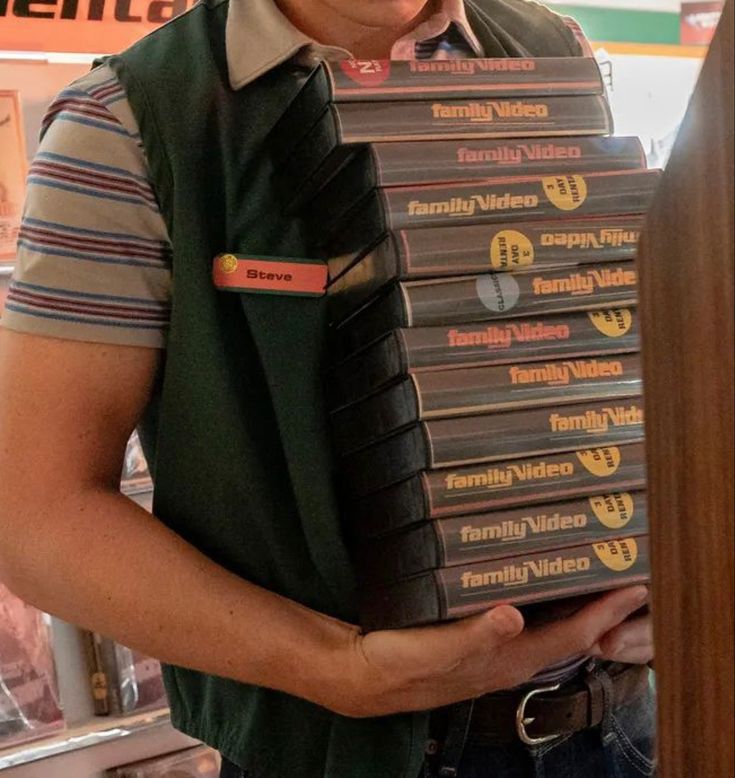 a man holding a stack of dvd's in his hands