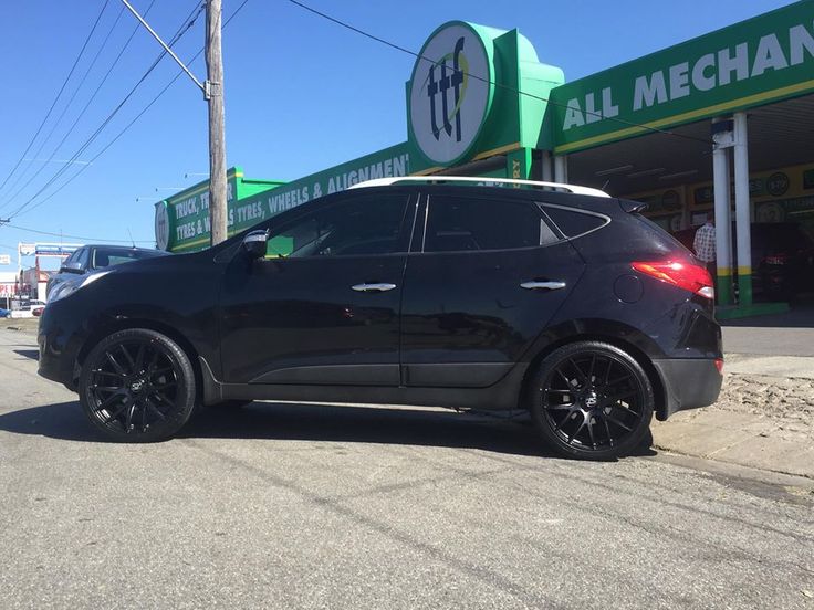 a black car parked in front of a gas station