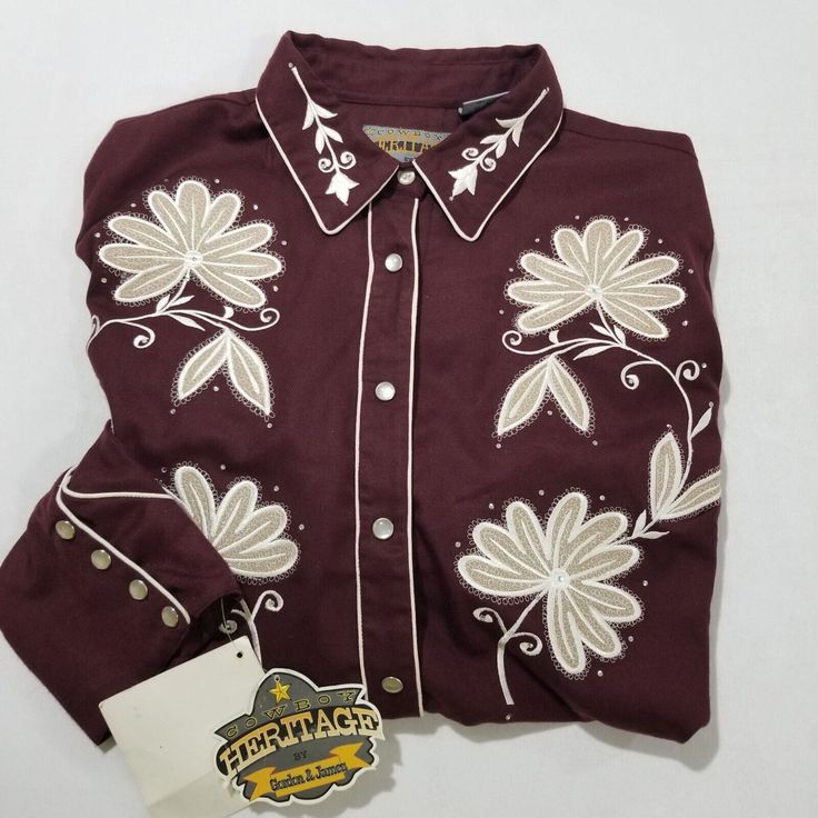 Add A Touch Of Western Style To Your Wardrobe With This Cowboy Heritage Gordon James Pearl Snap Shirt. The Shirt Features A Beautiful Floral Pattern And Is Made Of A Comfortable Blend Of Polyester, Polyester Blend, And Viscose Soft Velour Flannel Material. The Long Classic/Fitted Sleeves And Collared Neckline Provide A Stylish And Comfortable Fit, While The Contrasting Trim And Embroidered Accents Add A Touch Of Elegance. The Shirt Is Perfect For Travel, Casual Wear, Or Even Business Attire, And Cowboy Shirt Pattern, Vintage Cowboy Clothes, Western Show Clothes, Western Show Shirts, Western Pearl Snap, Pearl Snap Shirt, Cowboy Rodeo, Cowboy Shirt, Rodeo Queen