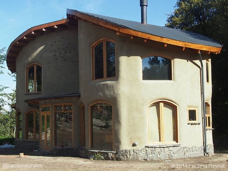 a house that is made out of concrete and has windows on the side of it