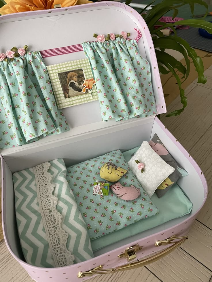 an open pink suitcase sitting on top of a wooden floor next to a vase with flowers