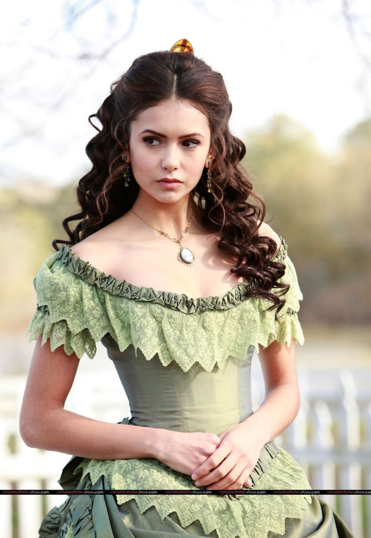 a woman with long hair wearing a green dress