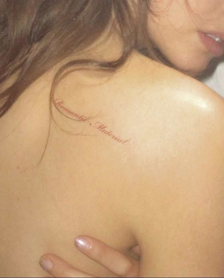 the back of a woman's shoulder with writing on it