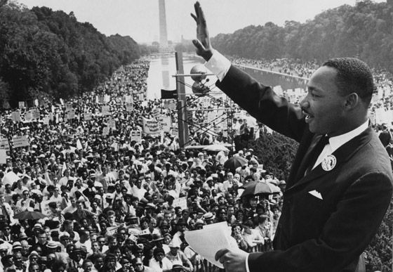 an old black and white photo of martin luther king giving a speech to a crowd