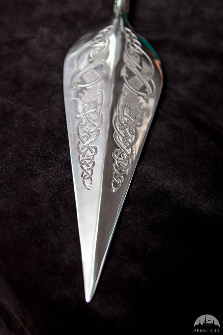 two silver spoons sitting on top of a black cloth