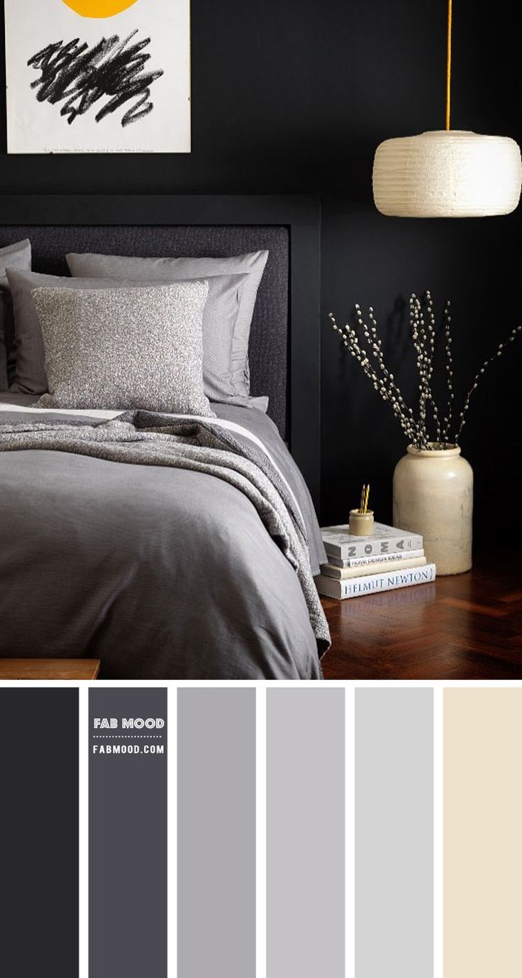 a bedroom with black walls and grey bedding