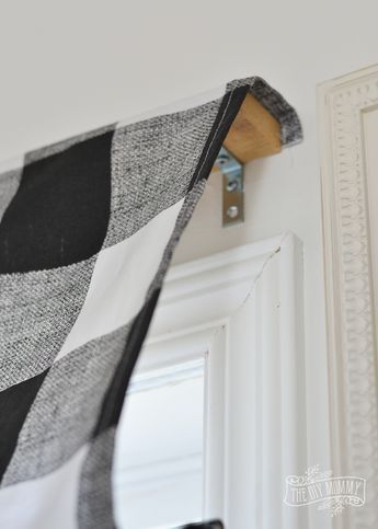 a black and white checkered blanket hanging on the wall next to a door handle