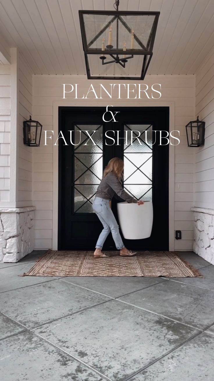 a woman carrying a surfboard into the front door of a house with text overlay that reads, planters & faux shrubs