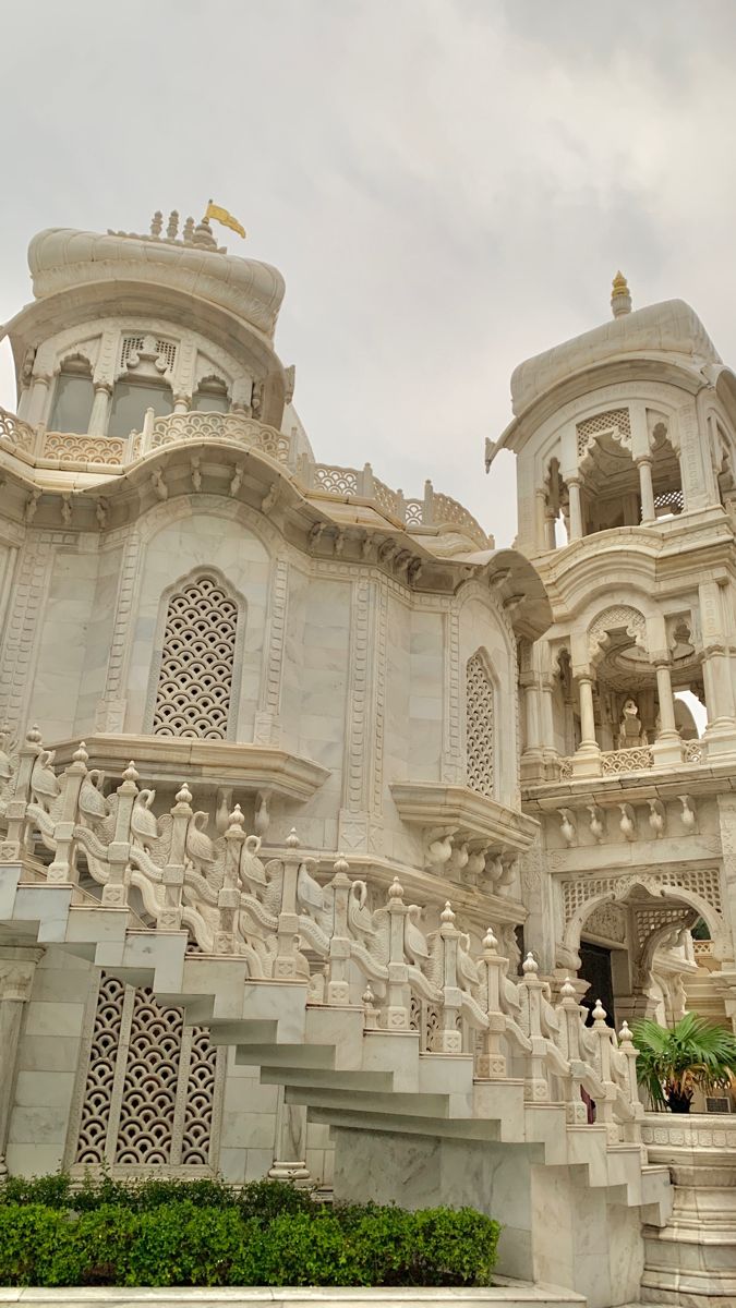 a large white building with many statues on it's sides and steps leading up to the top