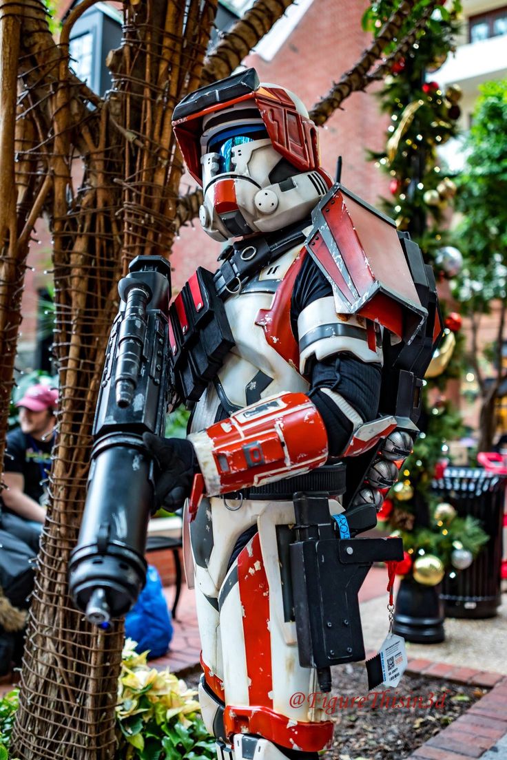 a man dressed as a star wars trooper standing next to a tree