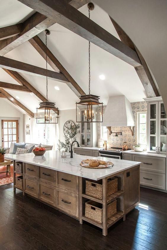 a large kitchen with an island in the middle and lots of wood beams on the ceiling