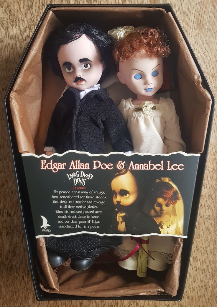 two dolls in an open box on a table