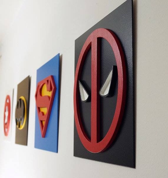 there are three different types of wall art on the wall, one is for deadpool and the other is for superman