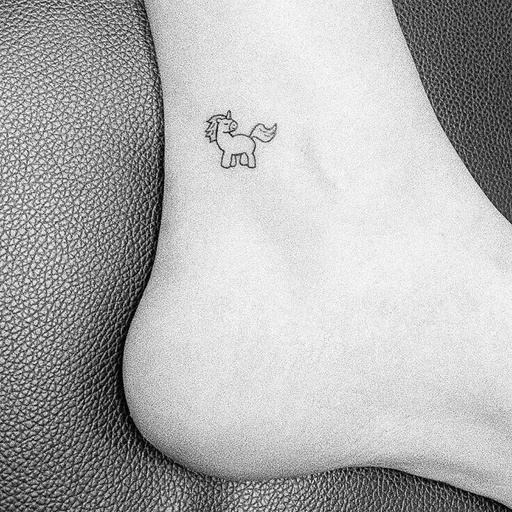 a small horse tattoo on the ankle is shown in this black and white photo,