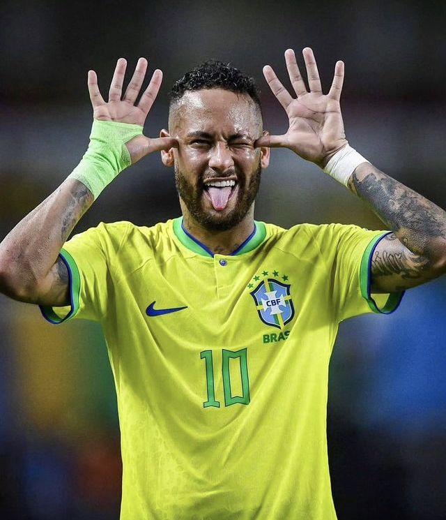 a man with his hands in the air while wearing a yellow shirt and green gloves