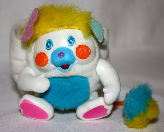 a close up of a stuffed animal toy on a white background with blue and yellow colors