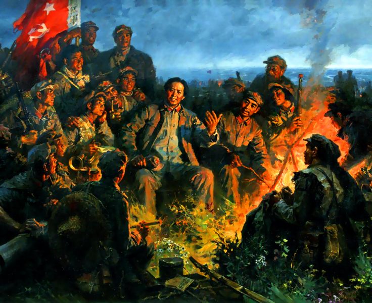 an image of a group of people sitting around a campfire with flags in the background