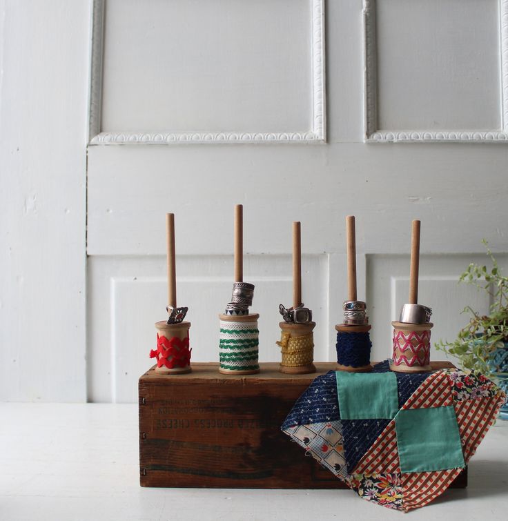 several spools of thread sitting on top of a wooden box