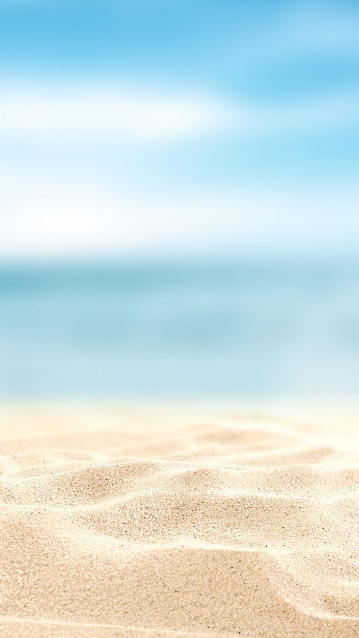 an empty beach with blue sky and water in the background is seen from the sand