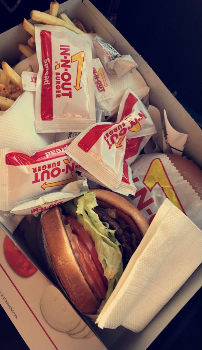 a box filled with lots of different types of food next to fries and ketchup