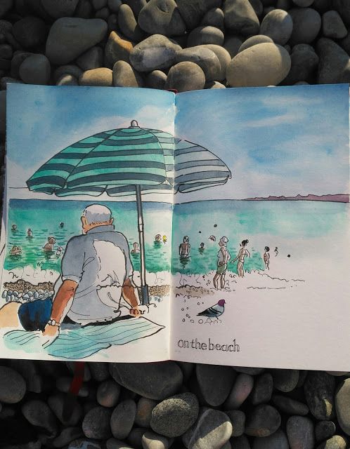 an open book sitting on top of a pile of rocks next to a beach filled with people