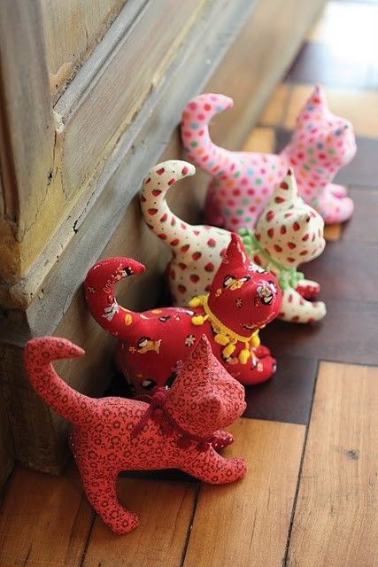 small ceramic figurines are lined up on the floor next to a wooden door